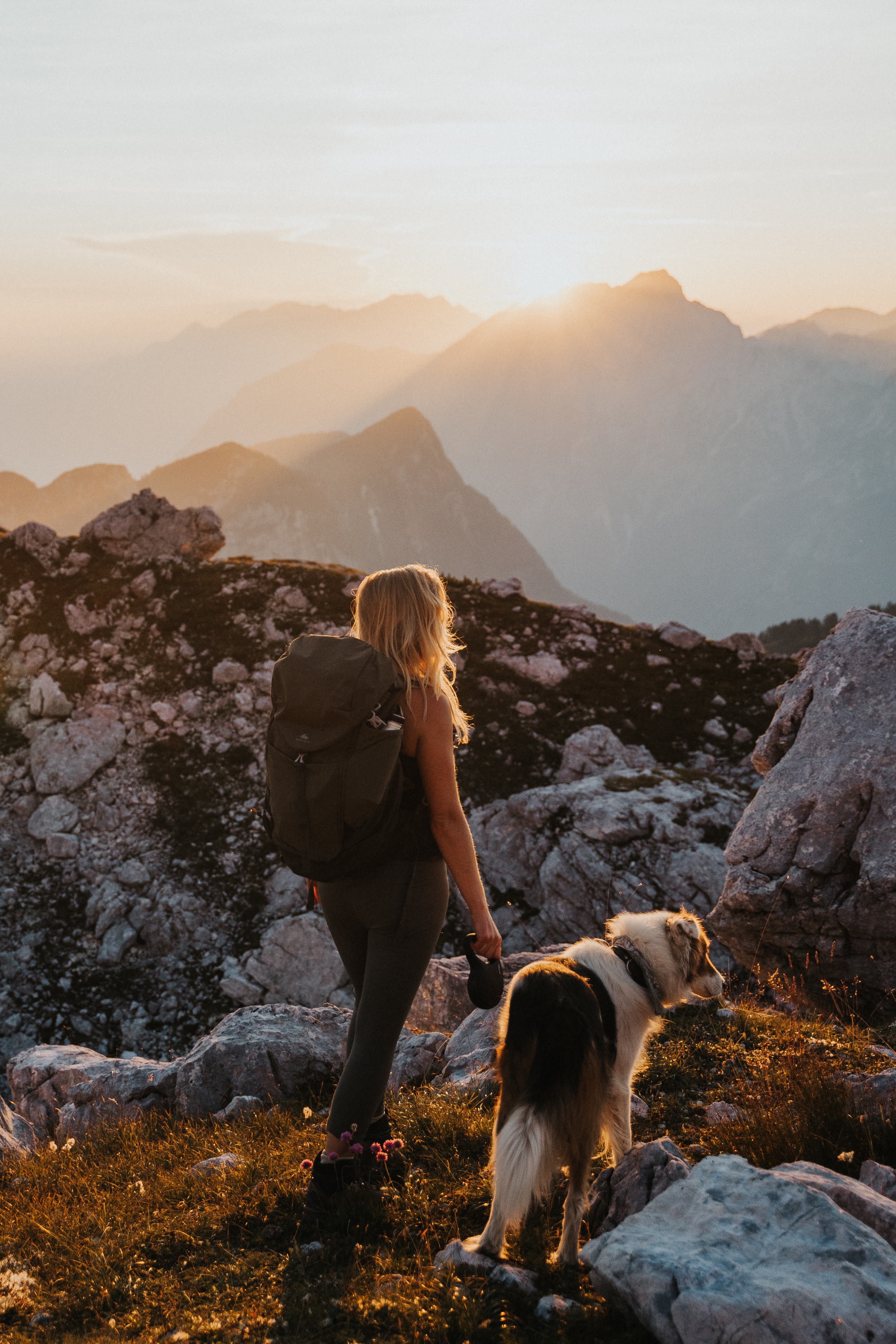 man-with-dog-standing-mountain-against-sky